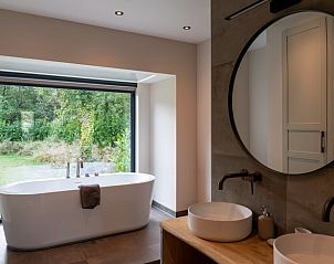 Modernes Badezimmer im Ferienhaus in Oosterhout mit groer Badewanne und Gartenblick in Nordbrabant.