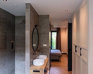 Luxurises Badezimmer eines Ferienhauses in Oosterhout mit begehbarer Dusche und Naturstein in Westbrabant.