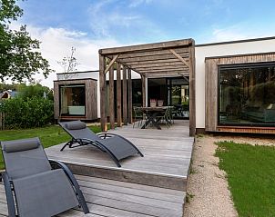 Sonnige Terrasse des Ferienhauses in Oosterhout mit Liegesthlen und Blick auf die Natur in Westbrabant.