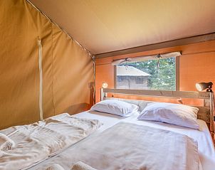 Gezellige slaapkamer in Safaritent 4, Oosterhout, Noord Brabant. Comfortabel glampingverblijf met uitzicht op de natuur.