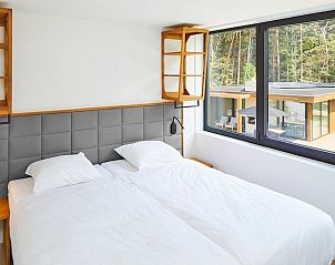 Helles Schlafzimmer mit Blick auf den Garten im Ferienhaus in Oosterhout, Westbrabant.