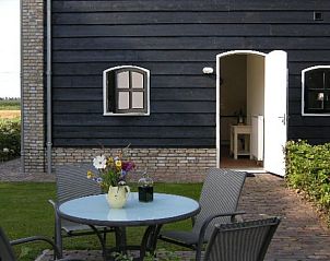 Terras van Huisje in Drimmelen, vakantiehuis in Noord Brabant met zitplek en groene omgeving.