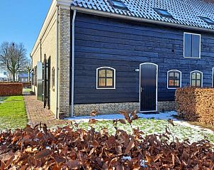 Zijaanzicht van Huisje in Drimmelen, vakantiehuis in West Brabant met houten gevel en winterse tuin.