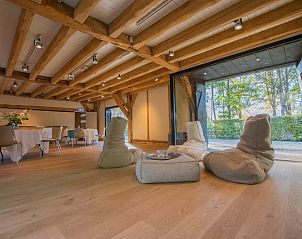 Interior of Jager en Hooijmijt vacation home in Ulvenhout AC, West Brabant, with wooden beams and cozy seating areas.