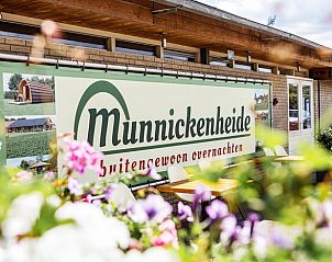 Ingang van Vakantiehuis in Terheijden, Noord Brabant, met kleurrijke bloemen en uitnodigend terras.