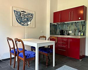 Stijlvolle eetruimte met rode keuken in Vakantiehuis in Herpt, West Brabant, voor een comfortabel verblijf.