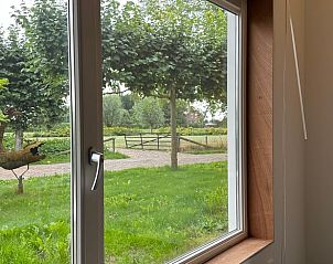 Uitzicht op de groene omgeving vanuit het raam van Vakantiehuis in Herpt, West Brabant, Noord Brabant.