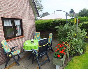 Zonnig terras met tuinmeubilair bij De Vlinder vakantiehuis in Schoorl