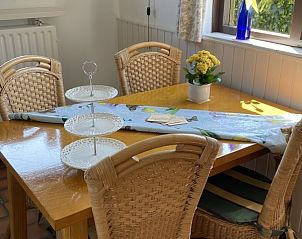 Eetkamer met houten tafel en stoelen in De Vlinder vakantiehuis, Schoorl