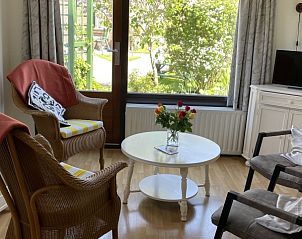 Gezellige woonkamer met uitzicht op tuin in De Vlinder vakantiehuis, Schoorl