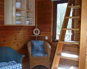 Houten trap naar zolder in Huisje no. 10, chalet in Schoorl, Noord-Holland, met gezellige zithoek.