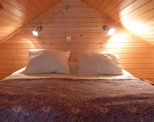 Sfeervolle slaapkamer met tweepersoonsbed in Huisje no. 10, chalet aan de Noordzeekust in Schoorl.