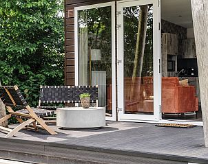 Veranda van Strandhuisje 6 personen in Julianadorp, Noord-Holland, met moderne zitplekken en uitzicht op groene natuur aan de Noordzeekust.