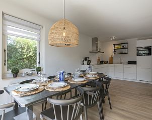 Eetruimte met uitzicht op de tuin in Duynopgangh 16 Julianadorp aan Zee, vakantiehuis in Noord-Holland.