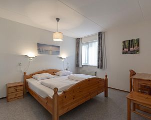 Ruime slaapkamer met houten meubels in Ooghduyne 148 Julianadorp aan zee.