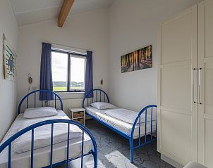 Slaapkamer met twee bedden en uitzicht in Ooghduyne 148 Julianadorp aan zee.