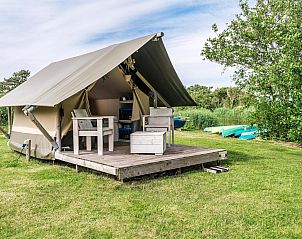 Duolodge 2 personen in Julianadorp biedt een knusse glamping ervaring aan de Noordzeekust met een charmante veranda en groene omgeving.