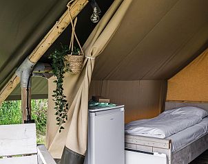 Gezellige binnenruimte van Duolodge 2 personen in Julianadorp, Noordzeekust. Compact vakantiehuis met knus bed en koelkast in Noord-Holland.