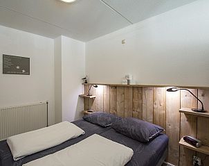 Slaapkamer met houten details in Strandslag 215 Julianadorp aan zee, vakantieverblijf aan de Noordzeekust.