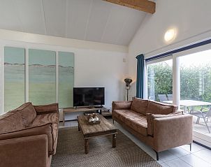 Lichte woonkamer met grote ramen in Ooghduyne 187 Julianadorp aan zee, vakantiehuis aan de Noordzeekust.