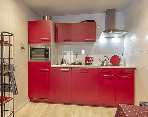 Keuken met rode kasten in Strandslag 103 Julianadorp aan Zee, vakantiehuis Noord-Holland.