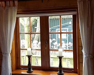 Uitzicht vanuit het raam van Vakantiehuis in Julianadorp, Noordzeekust, met kaarsen op de vensterbank.