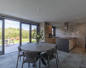 Ruime keuken en eetgedeelte in Wellness Villa Lotje, vakantiehuis in Julianadorp met uitzicht op de tuin.