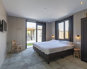 Slaapkamer in Wellness Villa Lotje, vakantiehuis in Julianadorp, met toegang tot de tuin.