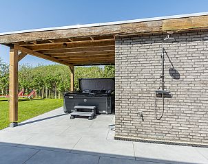 Overdekte jacuzzi en buitendouche in de tuin van Wellness Villa Lotje, vakantiehuis in Julianadorp.