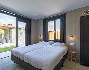 Slaapkamer met uitzicht op de tuin in Wellness Villa Lotje, vakantiehuis in Julianadorp.