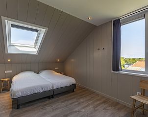 Slaapkamer op de bovenverdieping van Wellness Villa Lotje, vakantiehuis in Julianadorp, met dakraam.