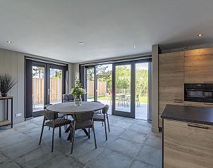 Eetkamer met uitzicht op de tuin in Wellness Villa Lotje, vakantiehuis in Julianadorp aan de Noordzeekust.