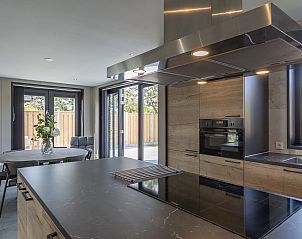 Moderne keuken in Wellness Villa Lotje, vakantiehuis in Julianadorp, met uitzicht op het terras.