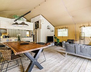 Gezellige binnenruimte van Strandtent 6 personen in Julianadorp, met houten interieur en comfortabele zithoek.