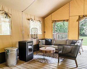 Comfortabele zithoek in Strandtent 6 personen, Julianadorp, met uitzicht op de groene omgeving.