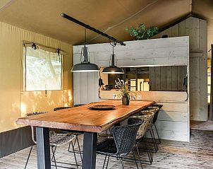 Eethoek in Strandtent 8 personen, Julianadorp, met houten tafel en moderne verlichting voor een sfeervol diner.