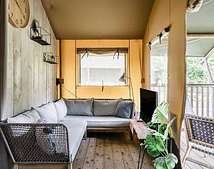 Gezellige zithoek in Strandtent 8 personen, Julianadorp, met uitzicht op de veranda en groene natuur.