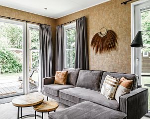 Gezellige woonkamer van Strandhuisje 4 personen in Julianadorp, Noordzeekust. Comfortabele zitruimte met uitzicht op de groene omgeving.