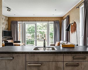 Gezellige binnenruimte van Strandhuisje 4 personen in Julianadorp, Noordzeekust. Vakantiehuis met uitzicht op groene tuin en moderne inrichting.