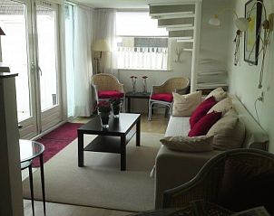 Lichte woonkamer in zomerhuis DEZEESTER, Egmond aan Zee, met comfortabele zithoek en moderne inrichting.