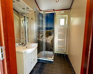 Chalet 4B, een vakantiehuis in Egmond aan Zee, Noordzeekust, Noord-Holland, omgeven door groene natuur en een zonnig terras.