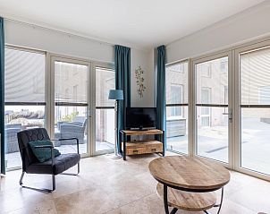 Lichte woonkamer in vakantiehuis De Platvis, Egmond aan Zee, met grote ramen en moderne inrichting aan de Noordzeekust in Noord-Holland.