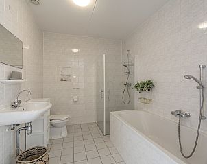 Modernes Badezimmer im Ferienhaus Duinerei B202 Groote Keeten, Callantsoog, mit Badewanne und Dusche.