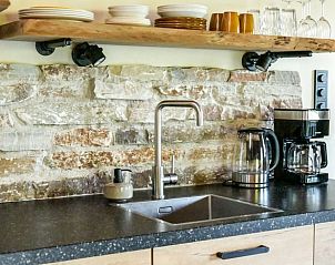 Modern kitchen with stone wall in Holiday home in Callantsoog, North Sea coast, North Holland.
