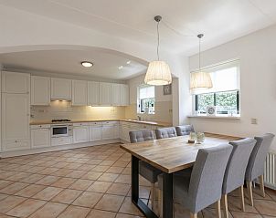 Dining room and kitchen in Buitenplaats 100 Callantsoog vacation home in North Holland with stylish decor.
