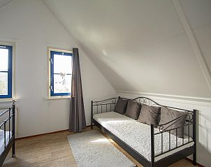 Comfortable bedroom with sitting area in Buitenplaats 100 Callantsoog vacation home in North Holland.