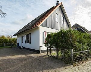 Front of Buitenplaats 100 Callantsoog vacation home on the North Sea coast in North Holland with green hedge.