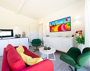 Moderne woonkamer van Tulip Mania 4 vakantiehuis in Callantsoog, Noordzeekust, Noord-Holland met kleurrijk interieur en comfortabele zithoek.