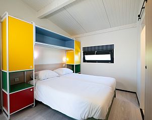 Sfeervolle slaapkamer in vakantiehuis Tulip Mania 4, Callantsoog, Noordzeekust, met kleurrijke kast en comfortabele bedden.