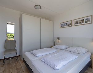 Bedroom with view in Duinerei C002 Groote Keeten vacation home in Callantsoog, North Sea coast, North Holland.